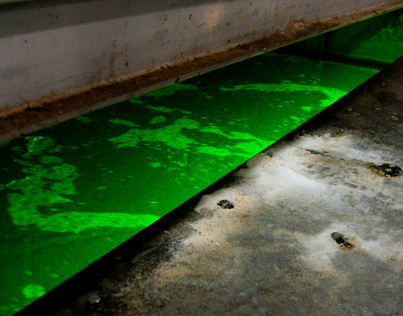 An industrial pool of water emanating a bright green glow.