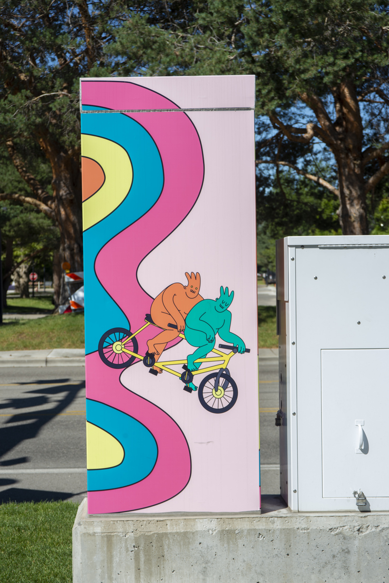 Side 1: Two cartoon characters riding a tantum bicycle.