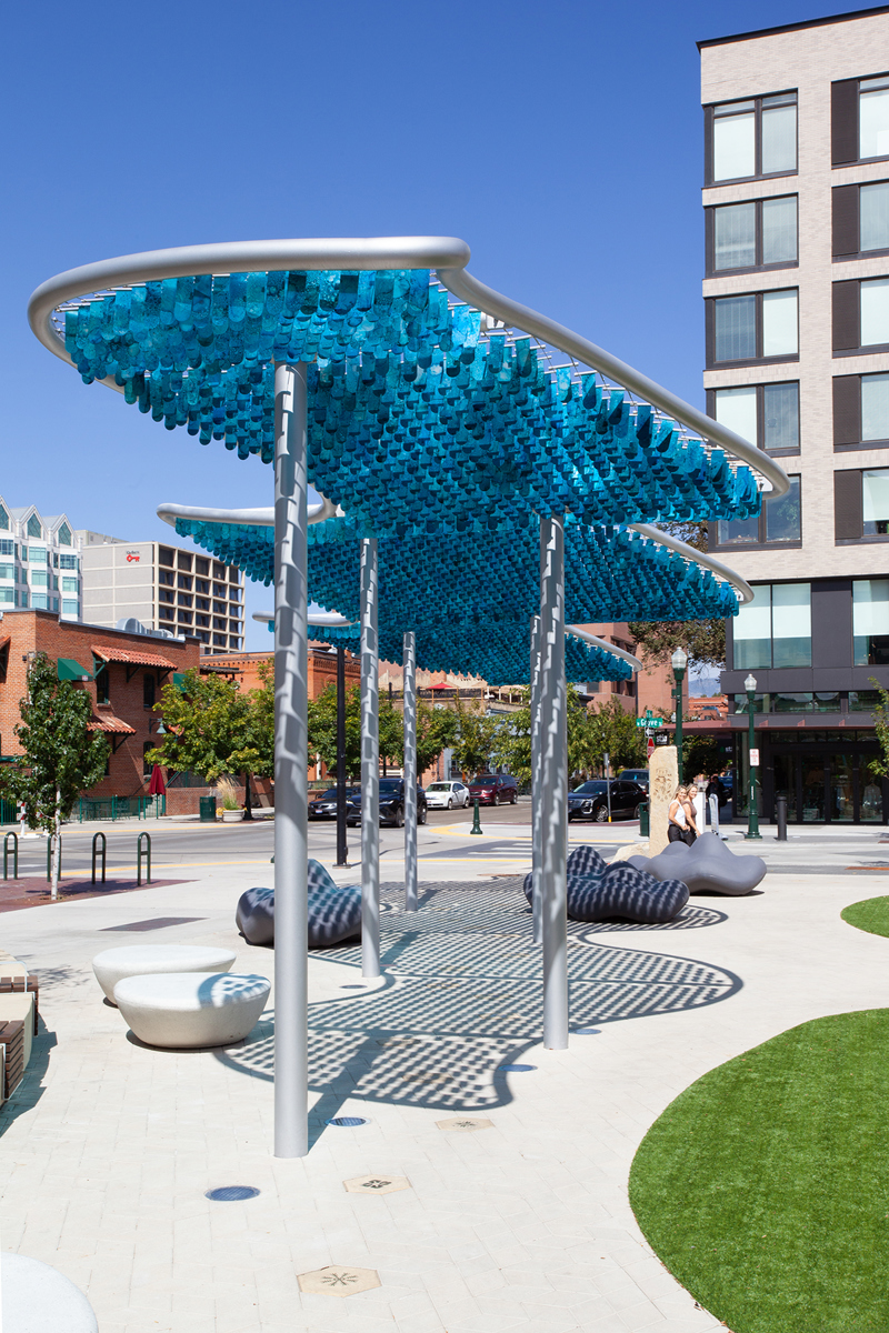 A shade canopy structure consisting of blue, alcohol painted flappers suspended in spanners set between stretched steel cables.