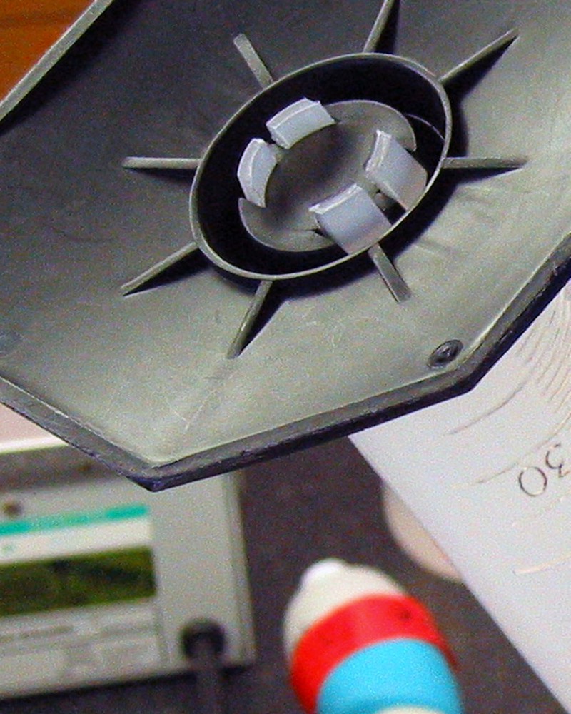 The black plastic bottom of a waste water sampling lab tube. In the unfocused background is various lab equipment.