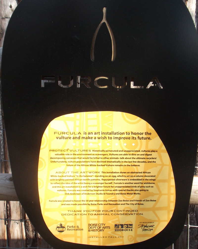 The signage for the sculpture Furcula which reads: "Furcula is an art installation to honor the vulture and make a wish to improve its future. Protect vultures. Historically persecuted and appreciated, vultures play a valuable role in the environment as scavengers. Vultures are able to dine on and digest decomposing carcasses that would be lethal to other animals, talk about the ultimate recyclers! Unfortunately, vulture populations have declined dramatically in the last few decades, and the fut