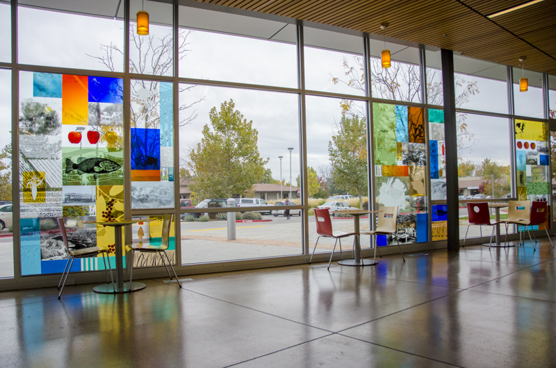 A set of three stained glass windows along the front of the Boise Library at Cole & Ustick. In the windows are images of plants and animals that reference the area's agricultural history.