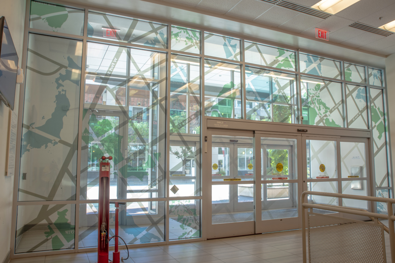 A transparent window vinyl depicting a map of Boise's streets overlayed atop silhouettes of various countries.
