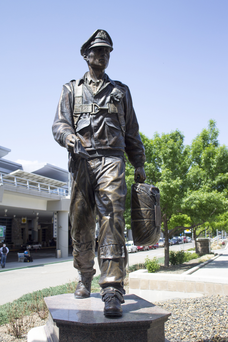 A large bronze sculpture of WWII aviator in mid-step. 