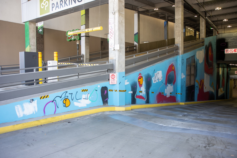 An abstract spray paint mural on both sides of the Boise VRT Main St. Station bus tunnel.