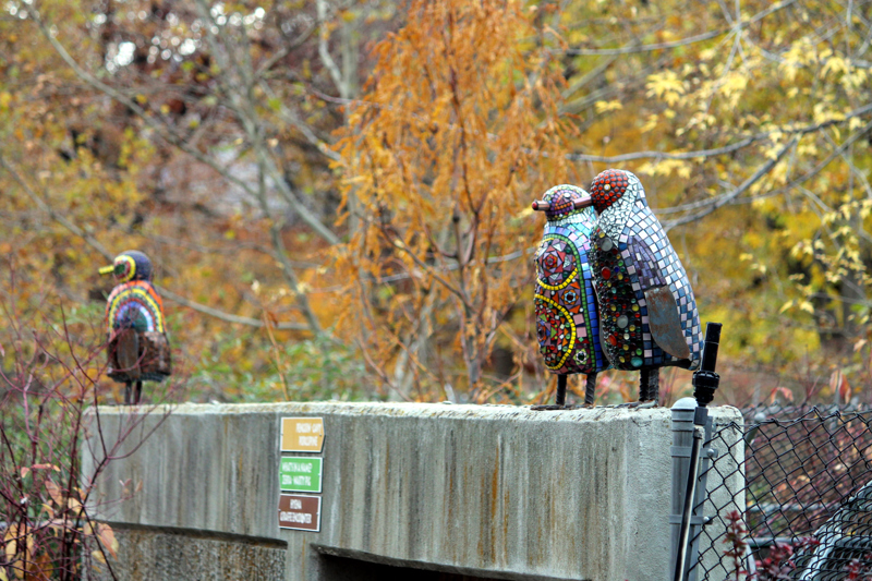 Two glass mosaic sculptures of penguins.