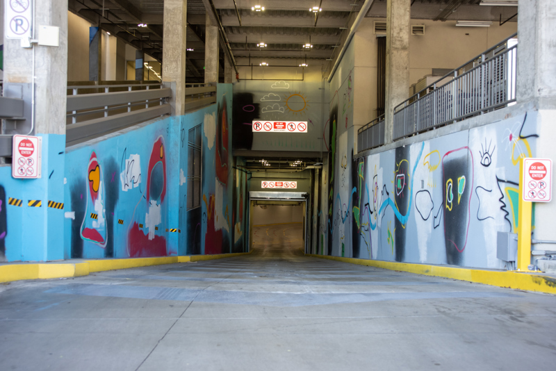 An abstract spray paint mural on both sides of the Boise VRT Main St. Station bus tunnel.