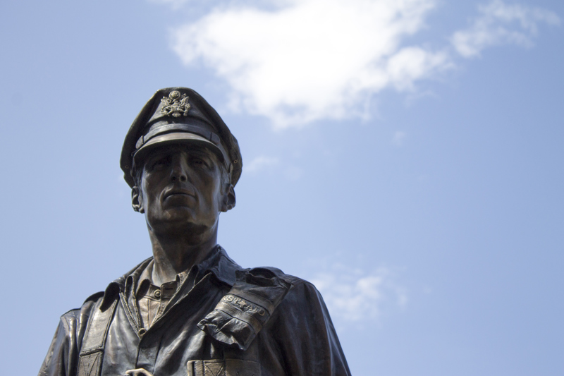A facial closeup of a large bronze sculpture of a WWII aviator. 