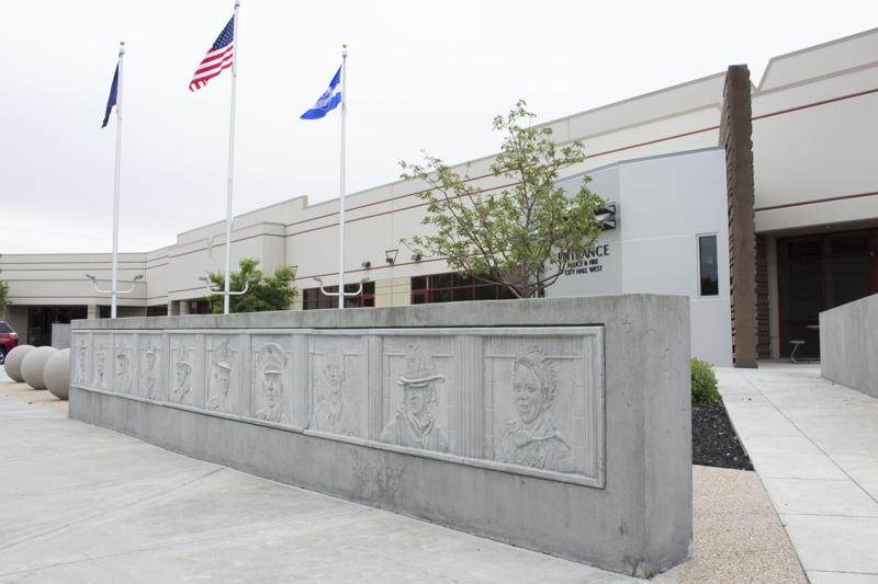A concrete wall with a low-bas relief sculpture depicting 10 portraits of professional first responders from Boise's history.