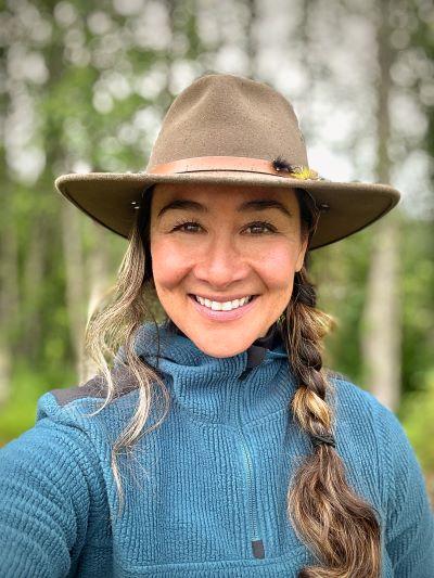 Kim Cross wearing hat with braided hair, smiling.